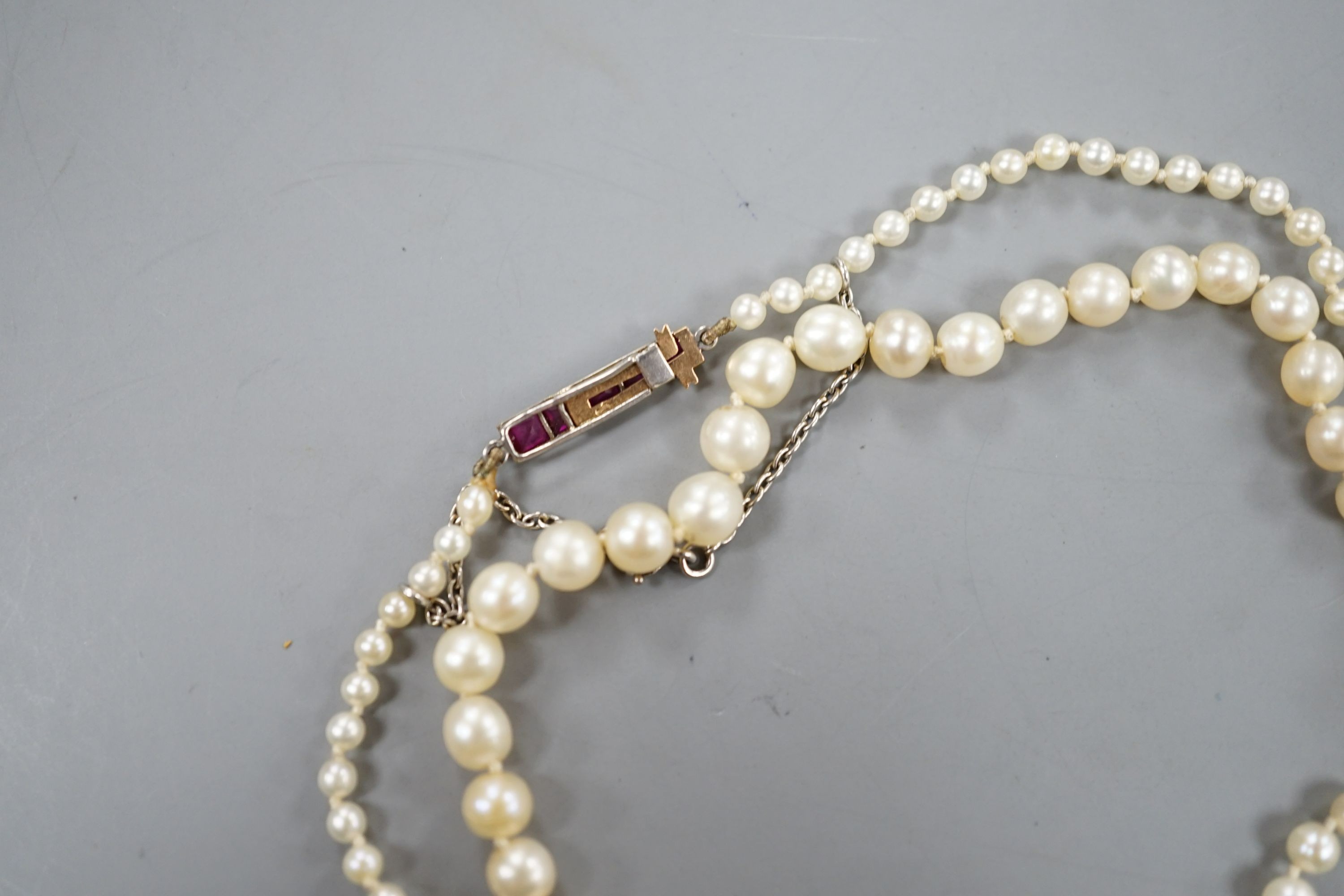 An early 20th century single strand graduated pearl necklace(pearls have not been tested as to whether or not they are natural), five stone ruby set yellow metal clasp, 44cm, gross weight 8.7 grams